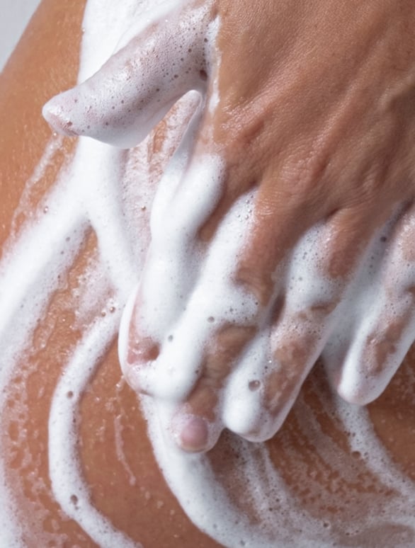women washing skin with foam ISVA body wash skincare routine